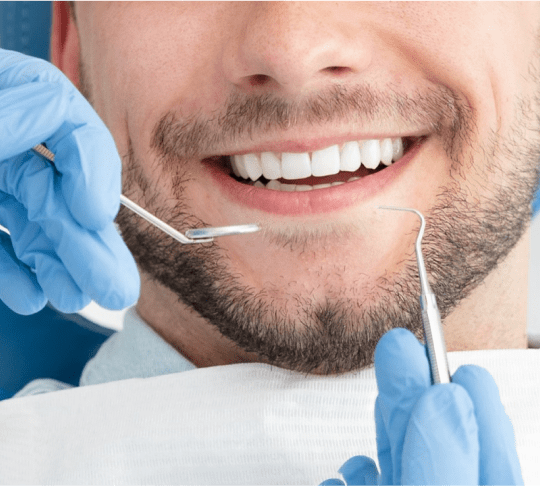 closeup of dentist performing teeth cleaning on man