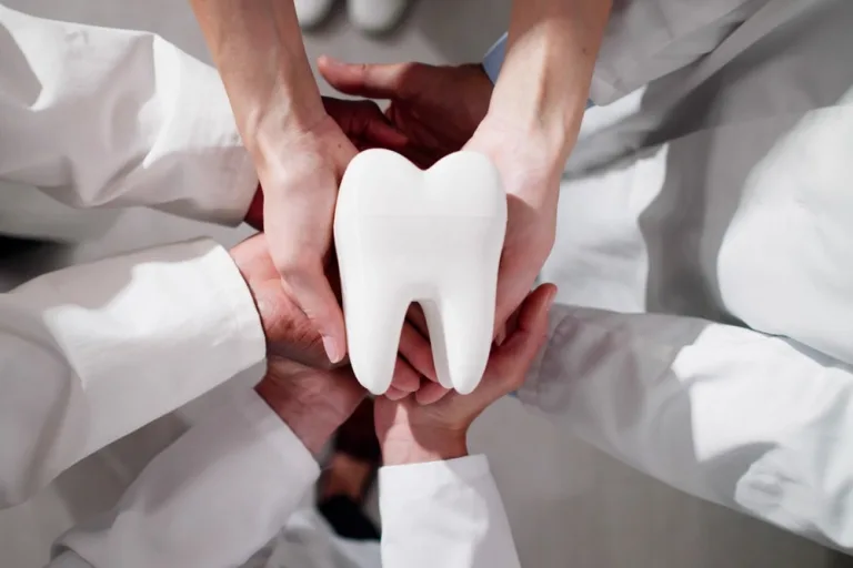 Group Of Dentists Holding Tooth. Dental Teeth Whitening.